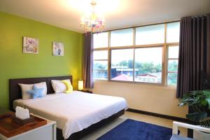a bedroom with a bed and a large window at Baan Nilawan Hua Hin Hotel in Hua Hin