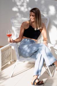 a woman sitting in a chair holding a glass of wine at Sunshine Coast Family Unit with Free Watersports, Maroochy River, Lagoon, and Beach Access in Twin Waters