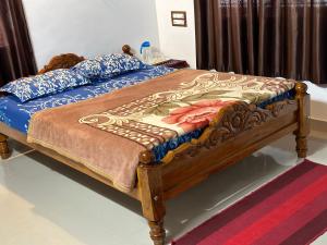 a bedroom with a bed with a blue comforter at Hill View Homestay Madikeri Coorg in Madikeri
