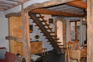 een woonkamer met een houten trap en een tafel bij Vakantiewoning BarCy in Heyd/Durbuy in Durbuy