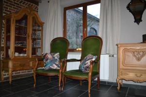 een kamer met 2 groene stoelen en een dressoir bij Vakantiewoning BarCy in Heyd/Durbuy in Durbuy