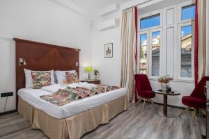 Habitación de hotel con cama, mesa y sillas en Continentale - Deluxe Rooms en Rijeka