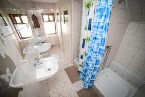 a bathroom with a sink and a shower at Na Poczatku - Apartamenty i Pokoje in Darłowo