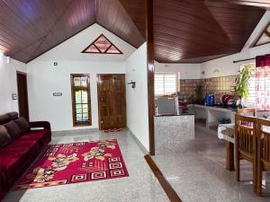 a living room with a red couch and a kitchen at Hill View Homestay Madikeri Coorg in Madikeri