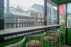 una fila di sgabelli in un bar con finestra di RedDoorz near Politeknik Manado a Paniki