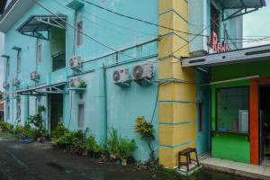 ein blaues und gelbes Gebäude an der Straßenseite in der Unterkunft RedDoorz near Politeknik Manado in Paniki