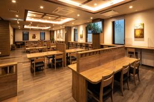 a dining room with wooden tables and chairs at Hotel Route Inn Matsuyama -Katsuyama Dori- in Matsuyama