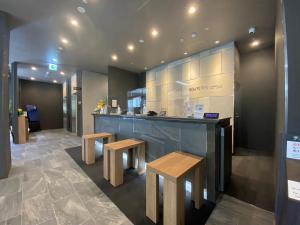 a kitchen with a counter and two benches and a bar at Hotel Route Inn Matsuyama -Katsuyama Dori- in Matsuyama