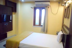 Habitación pequeña con cama y ventana en Tris Planet Kalyani by Easygorooms!!, en Kalyani