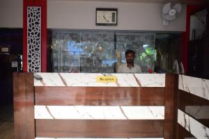 un hombre parado detrás de un mostrador en un restaurante en Tris Planet Kalyani by Easygorooms!!, en Kalyani