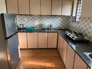 a kitchen with white cabinets and a counter top at Solomon Apartments,Alappuzha beach. in Alleppey