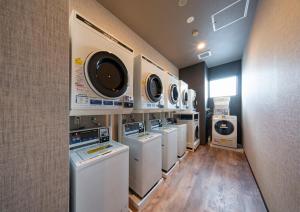 a laundry room with a row of washers and dryers at Hotel Route Inn Osaka Izumifuchu in Izumi