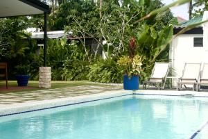 a swimming pool with two chairs and a house at Private Residences Siargao in General Luna