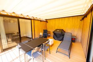 ISUMI Glamping Resort ＆Spa SOLAS في Isumi: سطح مع طاولة وكراسي خيمة