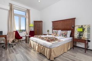 1 dormitorio con 1 cama grande, escritorio y sillas en Continentale - Deluxe Rooms en Rijeka