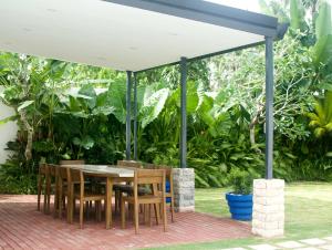 une table et des chaises sous un auvent blanc dans l'établissement Private Residences Siargao, à General Luna