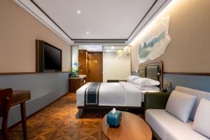 a hotel room with a bed and a couch at Nostalgia S Hotel Hangzhou West Lake in Hangzhou