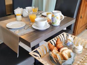 een tafel met een dienblad met brood en glazen sinaasappelsap bij Les Jardins de Virginie in Archignac