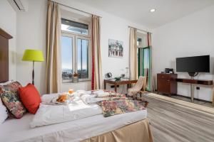 a hotel room with a bed and a television at Continentale - Deluxe Rooms in Rijeka