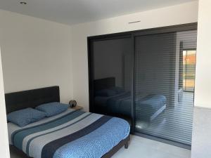 Schlafzimmer mit einem Bett und einem großen Glasfenster in der Unterkunft La Pousada in Peuplingues