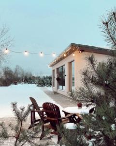 una casa con dos sillas y una mesa en la nieve en Hercogi, 