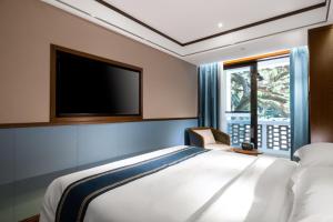 a bedroom with a bed and a flat screen tv at Nostalgia S Hotel Hangzhou West Lake in Hangzhou