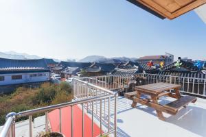a balcony with a wooden bench and a view of a city at Byeolha Guesthouse in Jeonju