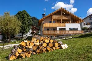 une pile de bûches devant une maison dans l'établissement Editlodge "Dessura", à Badia