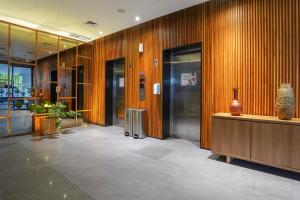 a lobby with wooden walls and a vase on a counter at BATIQA Hotel Lampung in Bandar Lampung