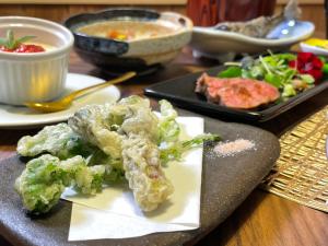 a table with a plate of food with broccoli on it at Harumiya Ryokan in Fukushima