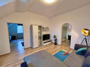 ein Wohnzimmer mit Sofa und Fernseher in einem Zimmer in der Unterkunft Bis 5 Personen, Parkplatz, Arbeitsplatz in Solingen