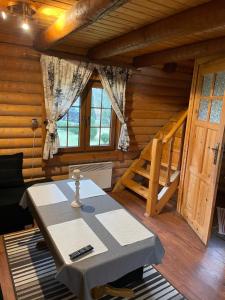 a room with a table in a log cabin at Domek z bali in Wojcieszyce