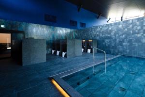 a swimming pool in a building at night at ISUMI Glamping Resort ＆Spa SOLAS in Isumi