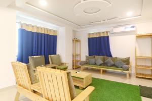 海得拉巴的住宿－FabHotel Green Leaf，客厅配有蓝色窗帘和沙发