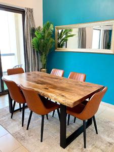 a dining room table with chairs and a blue wall at Full Sea View 2 bedroom Apartment in Dubai Marina JBR in Dubai