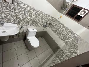 La salle de bains est pourvue de toilettes et d'un lavabo. dans l'établissement Solomon Apartments,Alappuzha beach., à Alappuzha