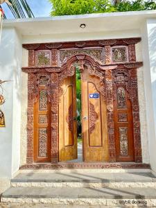 a pair of wooden doors on a building at Warisan Villa By Reccoma in Nusa Lembongan