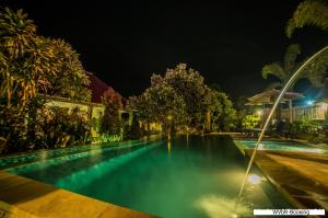 a swimming pool at night with lights on at Warisan Villa By Reccoma in Nusa Lembongan