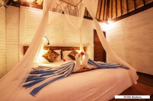 a bedroom with a bed with a swing at Warisan Villa By Reccoma in Nusa Lembongan