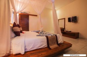 a bedroom with a bed with a canopy at Warisan Villa By Reccoma in Nusa Lembongan