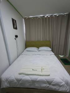 a bed with a white towel on top of it at OYO Home 90723 Green Leaf Guest Lodge Kk in Kota Kinabalu