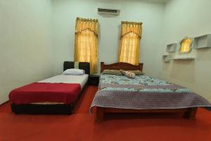 OYO Home 90723 Green Leaf Guest Lodge Kk في كوتا كينابالو: سريرين في غرفة بها نافذتين