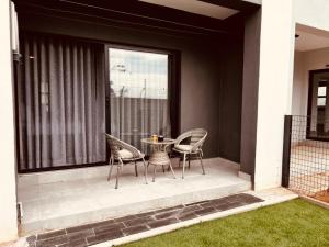 a patio with chairs and a table and a window at StudioA102 Sarona in Broadhurst