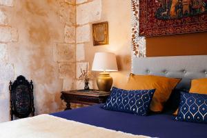 a bedroom with a bed and a table with a lamp at Logis de la MOTTE FÉODALE in Le Mesnil-Jourdain