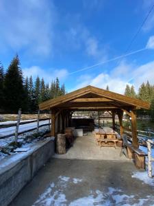 um pavilhão de madeira com bancos num campo em Etno kuća ''Nada'' em Jahorina