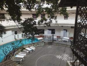 un patio con sillas y una piscina en un edificio en The Hans Hotel, en Hubli