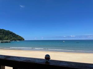a hat sitting on a fence on a beach at Tiongman Scubadive & Lodge in Tioman Island