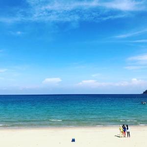 a group of people standing on a beach with the ocean at Tiongman Scubadive & Lodge in Tioman Island