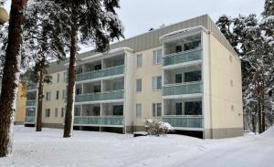 un edificio de apartamentos con nieve delante en Huttu - Ihqu kaksio mahtavalla sijainnilla, en Iisalmi