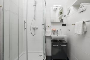a white bathroom with a shower and a sink at Continentale - Deluxe Rooms in Rijeka +47 photos